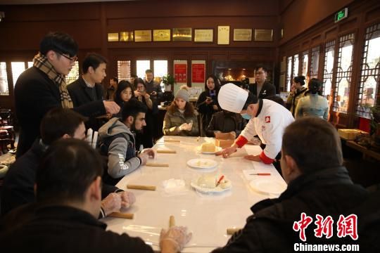  图为：首批“西湖旅游国际体验师”现场制作吴山酥油饼。　吴山管理处供图